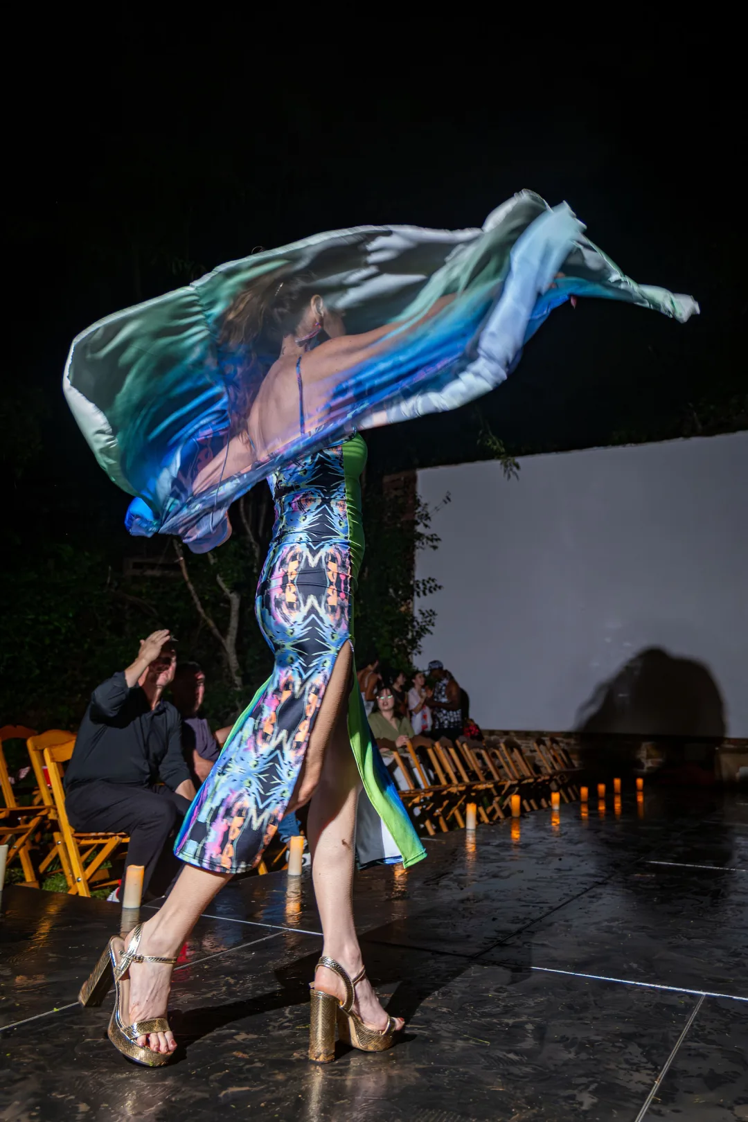 A model spins on the candle-lit runway, dress flaring, at Luxe in Love