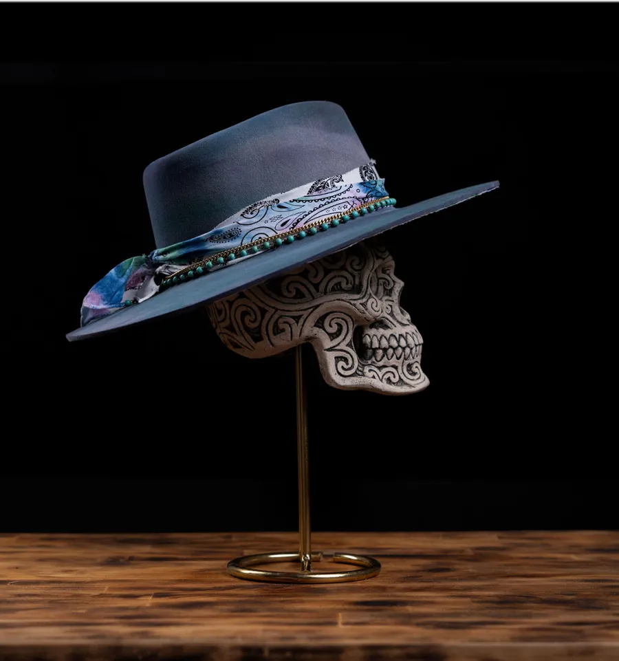 A Skull Flower Co felt hat displayed on a hand-painted skull at Luxe in Love